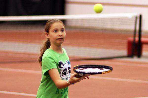 a girl playing tennis on a court