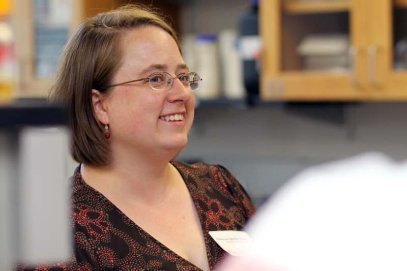 a woman wearing glasses and a name tag