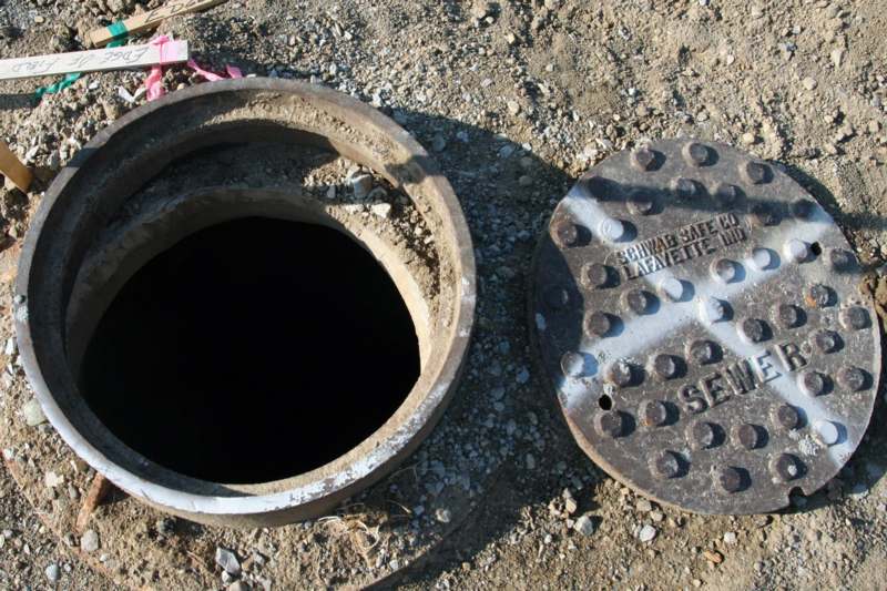 a manhole with a hole in the ground