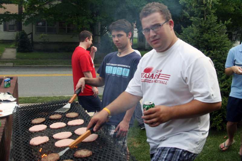 a group of men grilling hamburgers