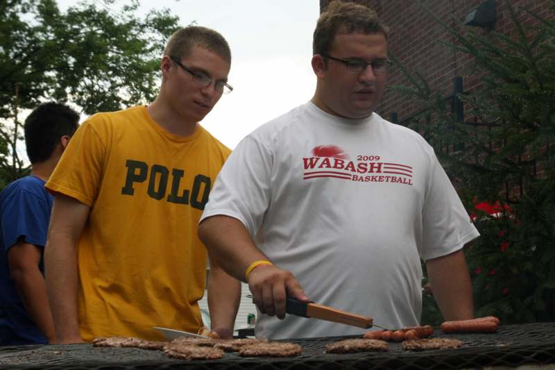a couple of men grilling food