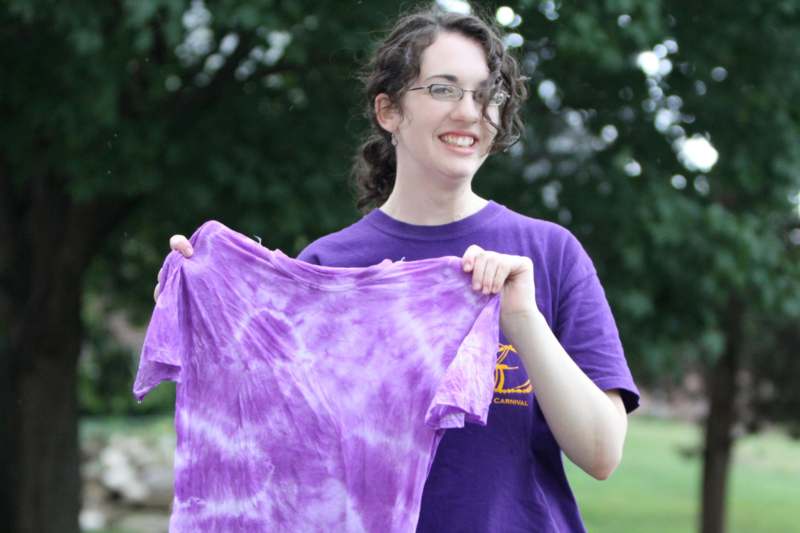 a woman holding a purple shirt
