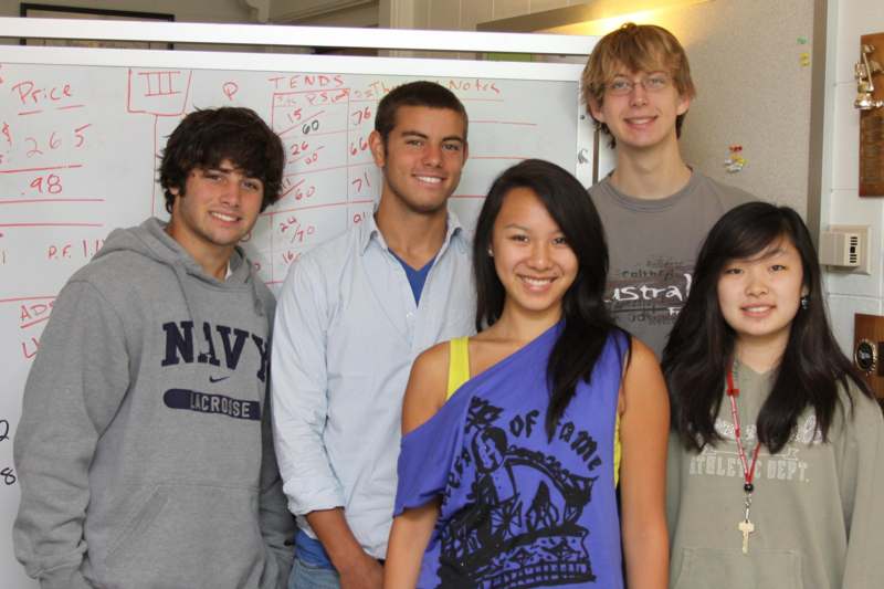 a group of people standing in front of a whiteboard