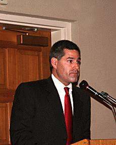 a man in a suit and tie standing in front of a microphone