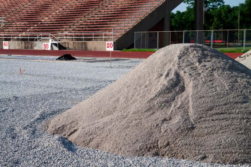 a pile of gravel next to a stadium