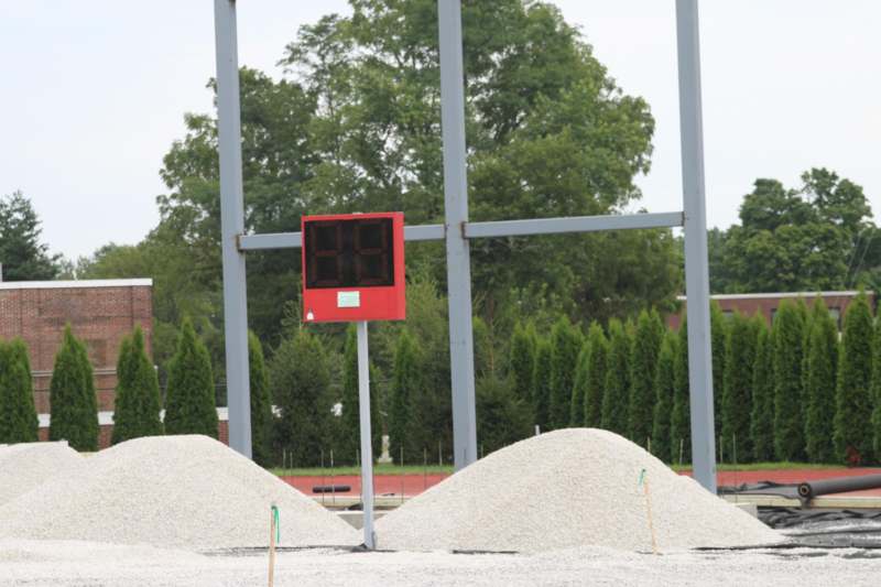 a scoreboard in front of piles of gravel