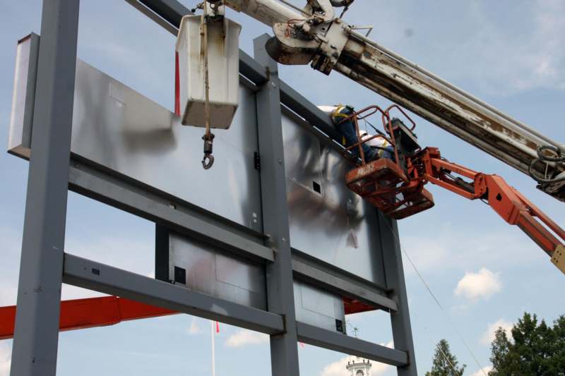 a man on a lift working on a metal structure