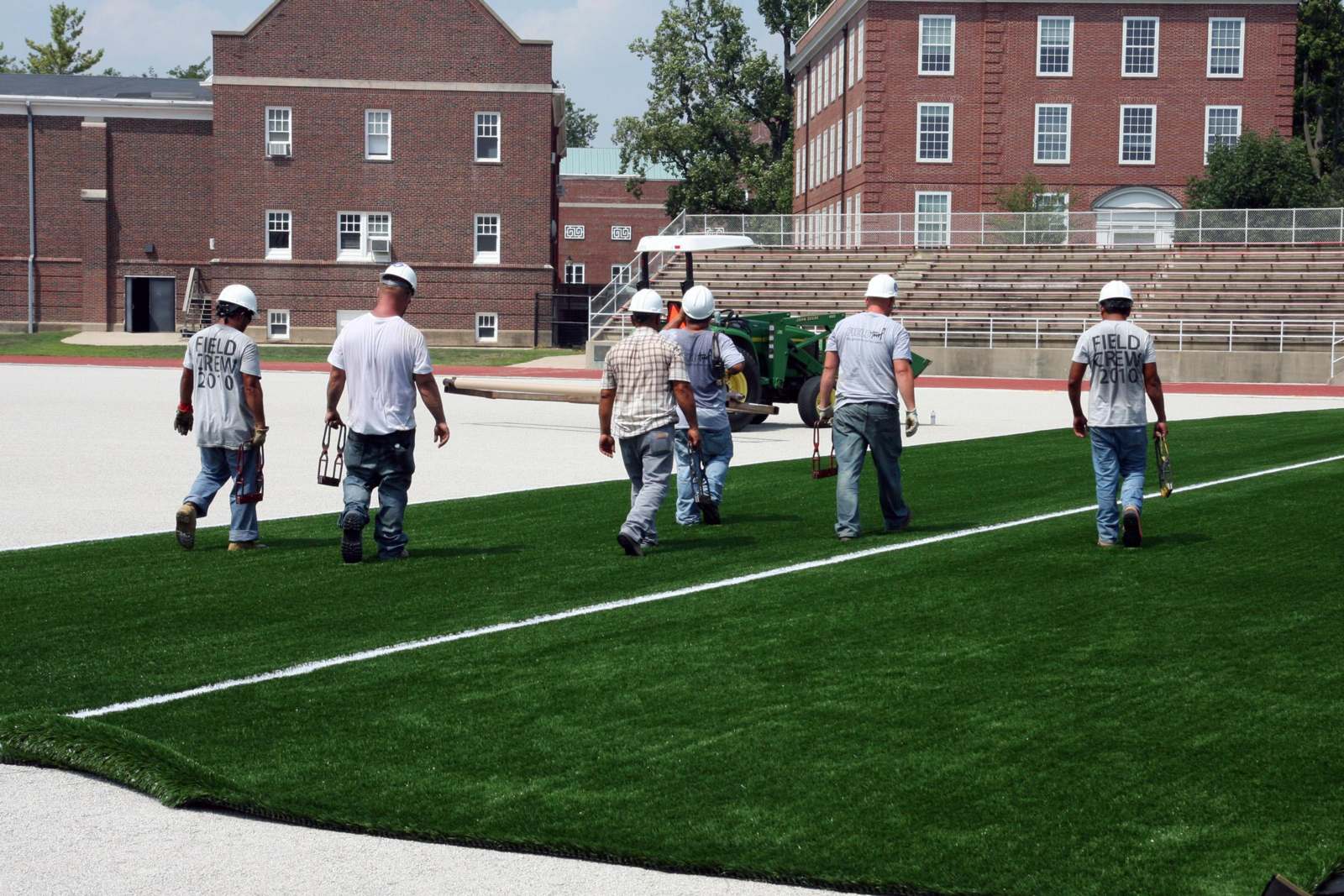 a group of men wearing white helmets walking on a field