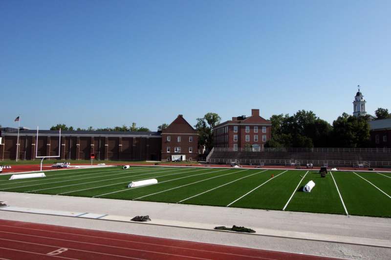 a football field with a building and a blue sky