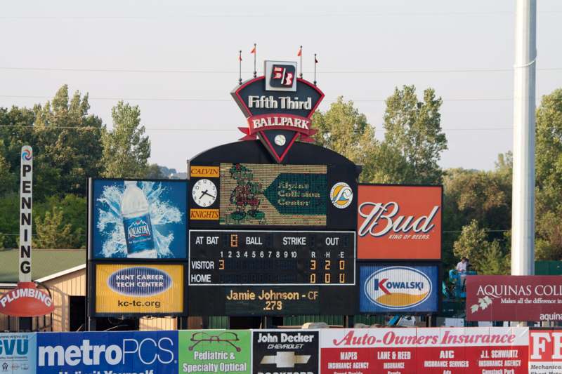 a scoreboard with a scoreboard and many advertising signs