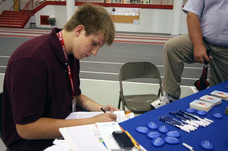 a young man signing a document