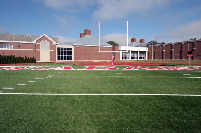 a football field with a brick building and a flag pole
