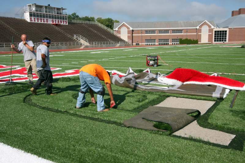 men working on a football field