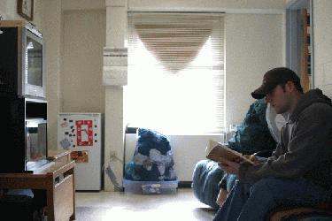 a man and woman sitting on a couch reading a book