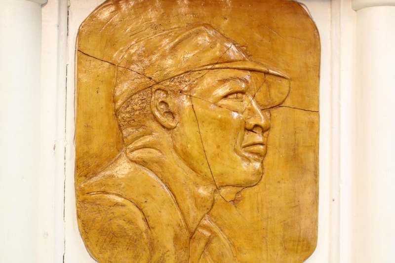 a carved wood carving of a man in a cap