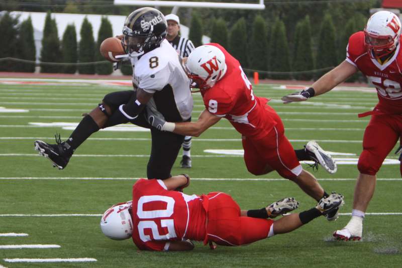 a football player falling off of another football player