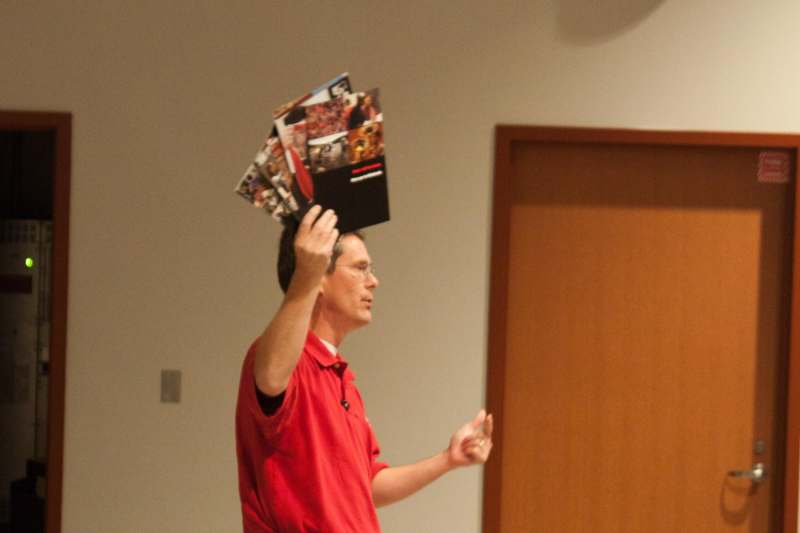 a man holding up a pile of magazines