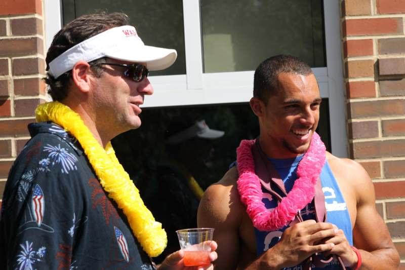 a couple of men wearing leis and drinking