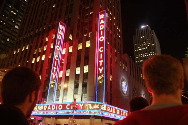 a group of people standing in front of Radio City Music Hall