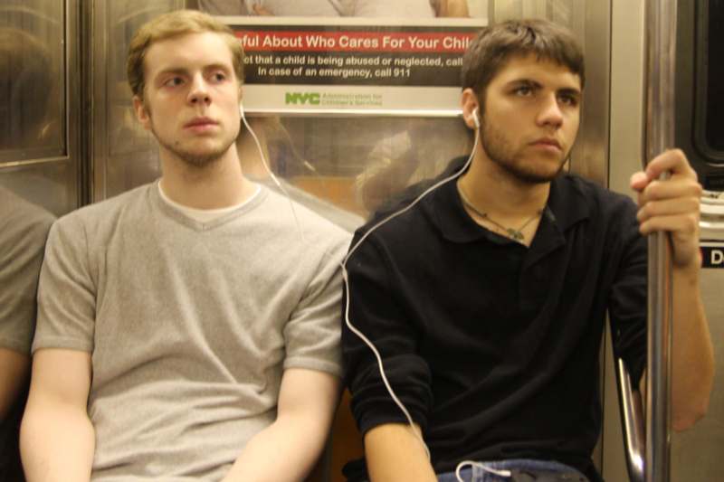 two men sitting in a train