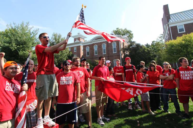 a group of people in red shirts holding flags