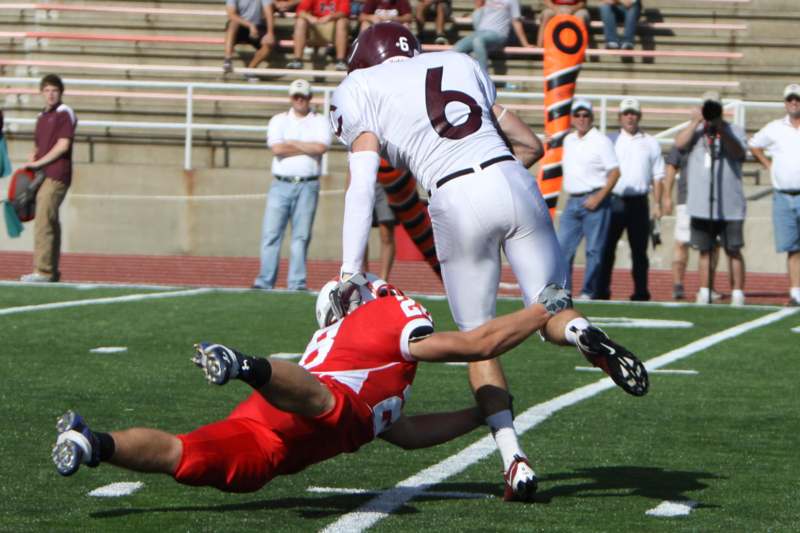 a football player falling over another football player