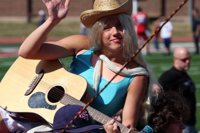 a woman in a cowboy hat holding a guitar