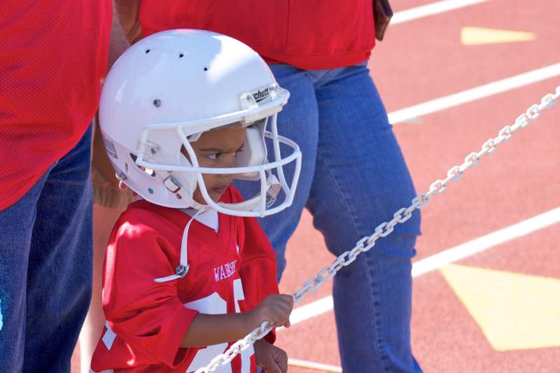a child wearing a helmet and holding a chain