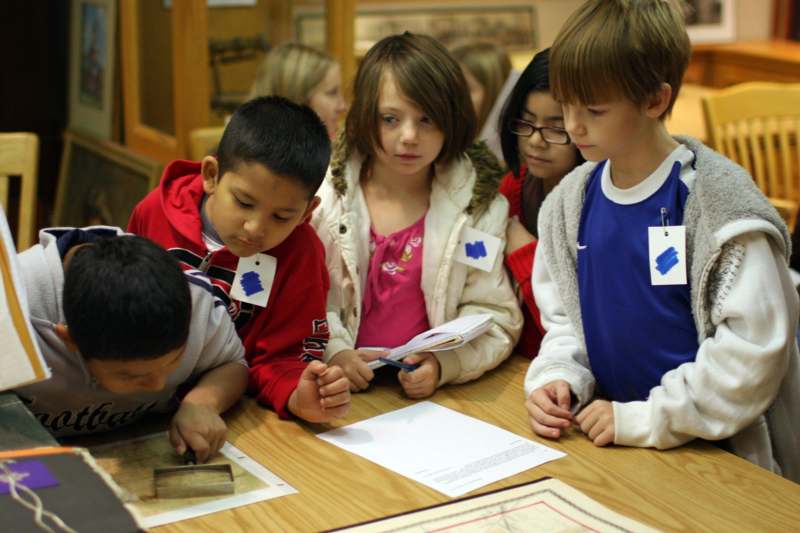 a group of children looking at a piece of paper