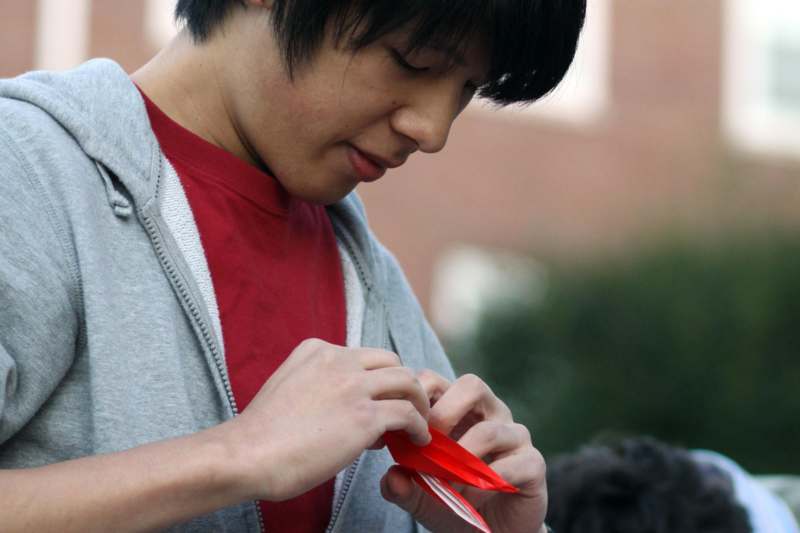 a man folding a red paper