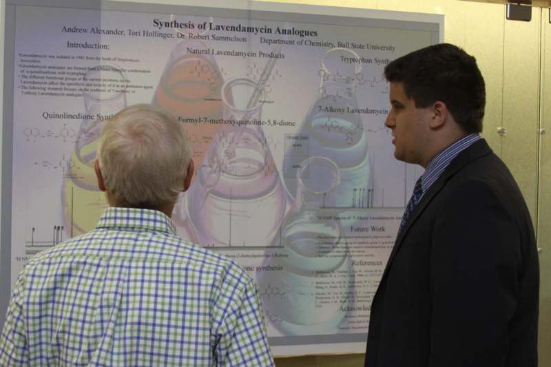 a man looking at a man in front of a poster