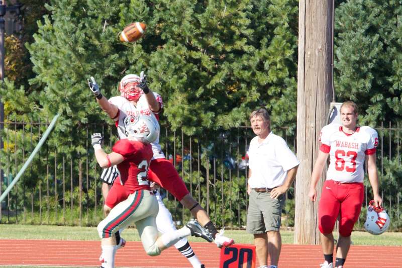 a football player jumping over a football
