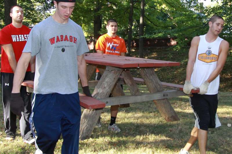 a group of men carrying a picnic table