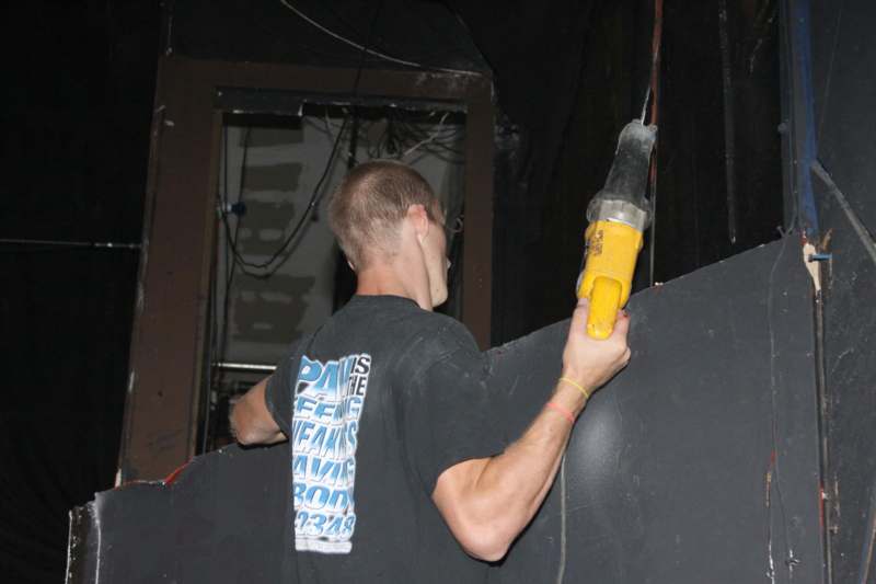 a man using a drill to cut a wall