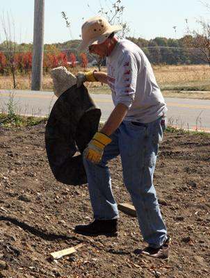 a man in a cowboy hat holding a tire