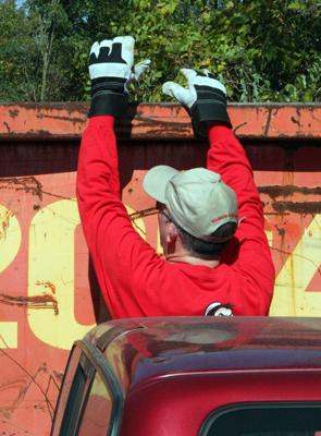 a man wearing gloves and standing in front of a truck