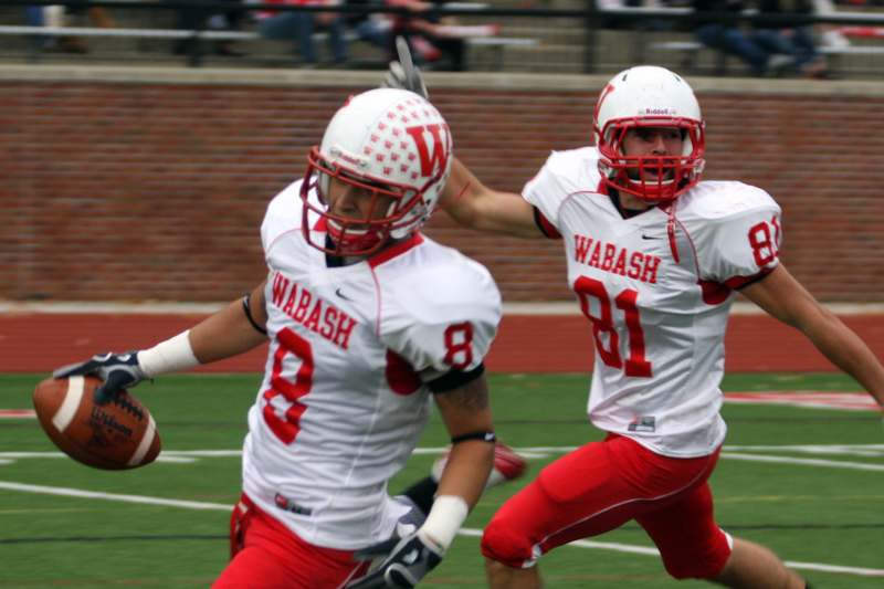 two football players running with footballs