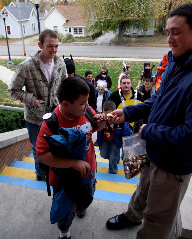 a man handing a small child a candy to a group of people