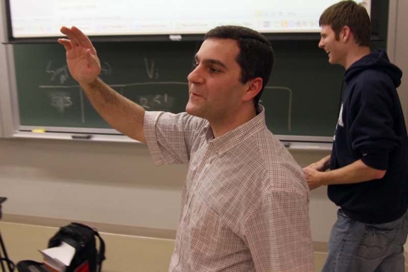 a man raising his hand in front of a chalkboard