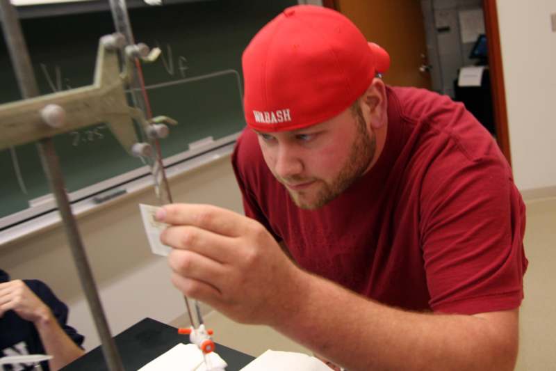 a man in a red hat working on a model