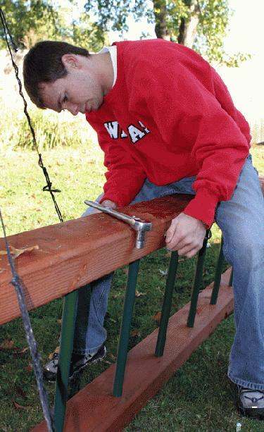 a man working on a wood railing