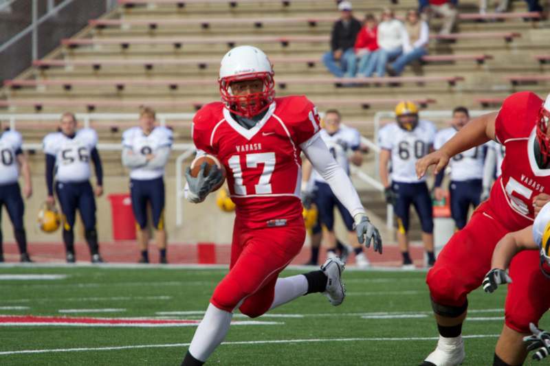 a football player running with a football in his hand