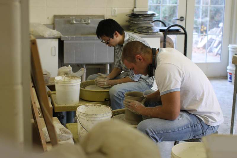 a couple of men working on a pottery wheel