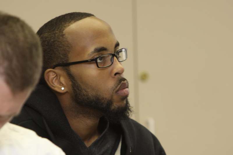 a man wearing glasses and a black hoodie