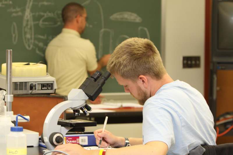 a man looking through a microscope