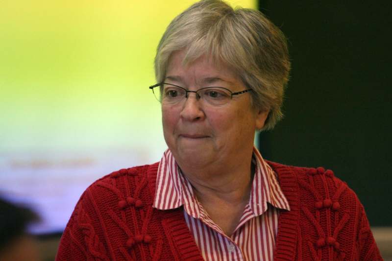 a woman wearing glasses and a red sweater