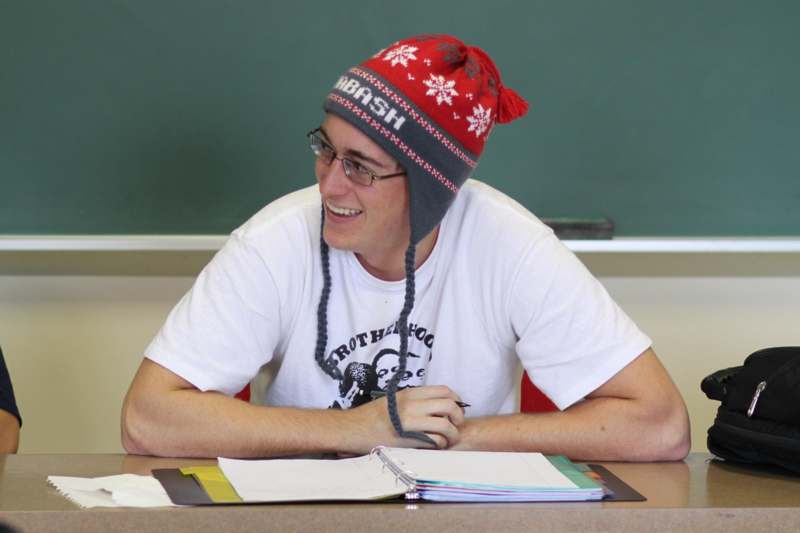 a man wearing a red and gray beanie and glasses