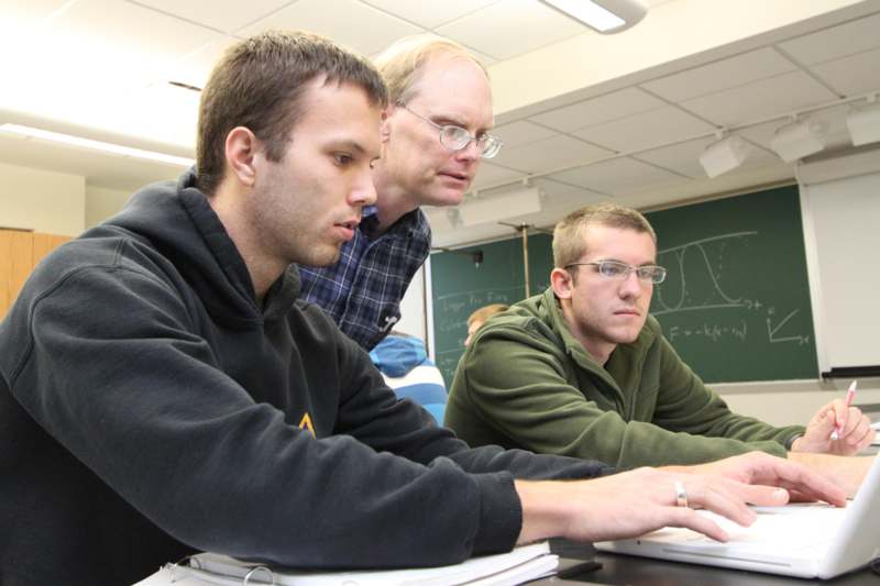 a group of men working on a computer