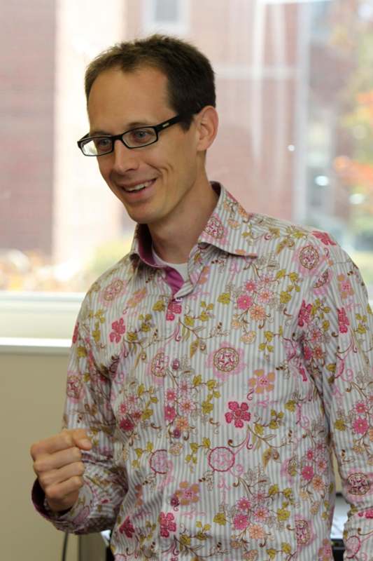 a man wearing glasses and a floral shirt