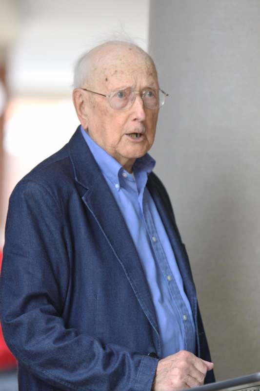 an old man wearing glasses and a blue shirt